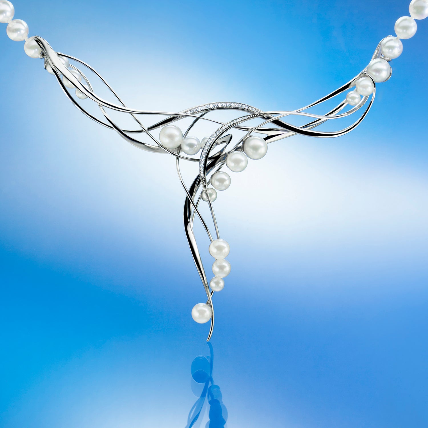 Silver necklace with pearls against a beige background